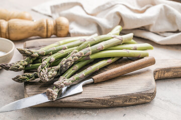 Asparagus cooking concept, top down view on a cutting board with fresh bunch of asparagus, spring healthy cooking idea