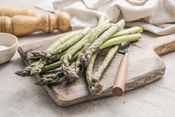 Asparagus cooking concept, top down view on a cutting board with fresh bunch of asparagus, spring healthy cooking idea