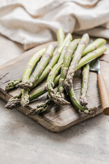 Asparagus cooking concept, top down view on a cutting board with fresh bunch of asparagus, spring healthy cooking idea