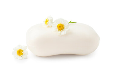 Soap bar and chamomile flowers on white background