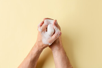 Man washing hands with soap on color background