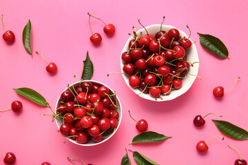 Bowls with tasty ripe cherry on color background