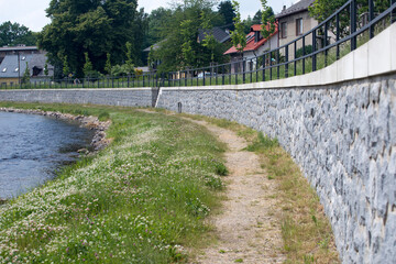 Modern flood protection wall in the style of the historic city wall. Permanent measures against floods. Dikes, gate valves, gates and walls. 
Flood gates protecting city against flooding from stream.