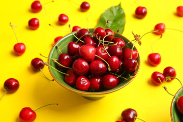 Fototapeta na wymiar Bowl with tasty ripe cherry on color background