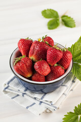 Fresh ripe strawberries in a bowl on a white background. Eco-products.