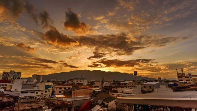 CHIANG MAI, THAILAND - JUNE 30 2021 : Time lapse of dramatic sunset sky with clouds moving in rainy season over the mountain and city
