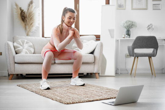 Young fitness girl doing sport exercises at her living room at home