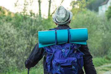 tourist man with backpack and map hiking or trekking up the mountain