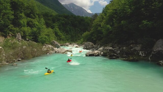 Panorama - Drifting over a turquoise Soča river with a few kayaks sailing over t