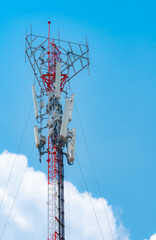 Telecommunication tower with blue sky and white clouds background. Antenna on blue sky. Radio and...