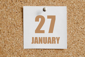 january 27. 27th day of the month, calendar date.White calendar sheet attached to brown cork board.Winter month, day of the year concept