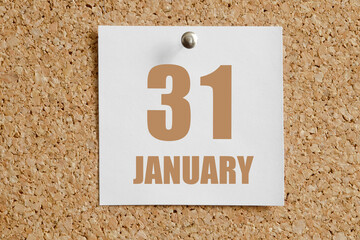 january 31. 31th day of the month, calendar date.White calendar sheet attached to brown cork...