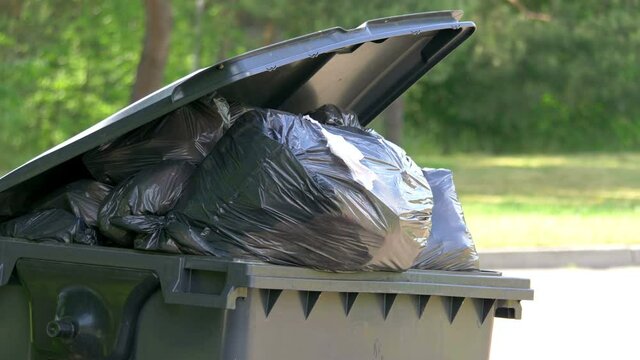 Overflowing trash container in 4k slow motion 60fps