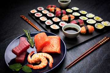 Fototapeta na wymiar Presentation of fish sushi and vegetable sushi with chopsticks and a plate with ingredients