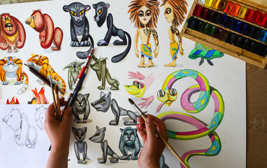 The animator draws with a pencil and draws characters from cartoons, comics or puppet shows. Mowgli's play. Preparing to make a doll. The designer creates sketches. Comics, cartoons, puppet theater