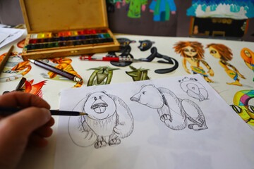 The animator draws with a pencil and draws characters from cartoons, comics or puppet shows....