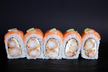shrimp and cheese sushi topped with salmon and lime. front view