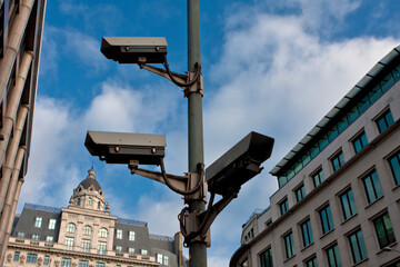 CCTV cameras in central London UK with buildings in the background with blue sky and some clouds...