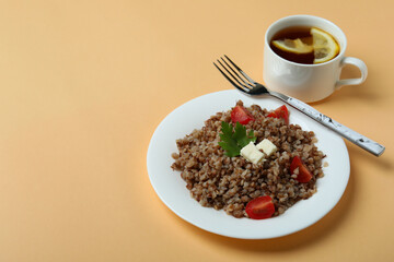 Concept of tasty eating with buckwheat on beige background