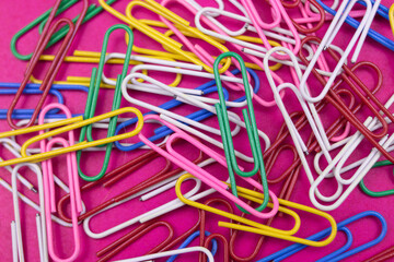 colorful paper clips on pink