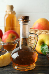 Homemade apple vinegar and ingredients on wooden table