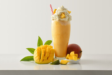 Mango milkshake with cream decorated with fruit on table isolated