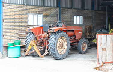 Obraz premium Old red tractor inside garage