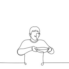 man carefully carries a deep round plate in front of him - one line drawing. a man stands or walks and holds a full plate by the edges