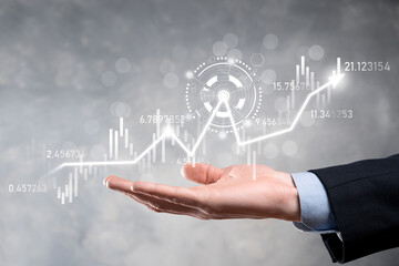 Businessman in hand hold banking business finance graph and invest in stock market investment point,economic growth and investor concept.analysis virtual stock market chart,analyze by use technology