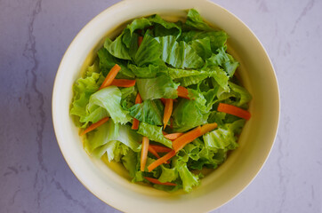 Green salad mixed with carrots, symbol of freshness and rich in minerals
