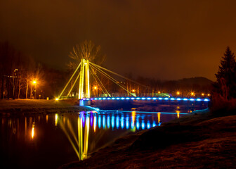 Fototapeta na wymiar The bridge over the Vistula in Ustroń lit up with coloured lights