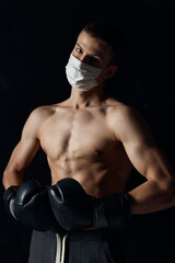 portrait of sportsman wearing boxing gloves and medical mask close-up cropped view 