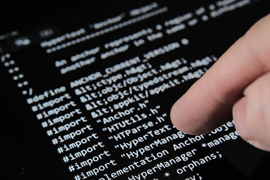 Blurred Finger touching tablet screen with the firts World Wide Web source code which was sold as NFT on auction. Selective focus. Concept. Stafford, United Kingdom, June 1, 2021