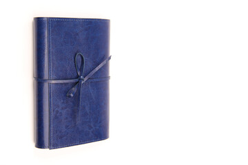 A blue diary in a blue leather cover for conducting business, recording contacts, making lists, decorated with a handmade author's ribbon on a white background. Copyspace