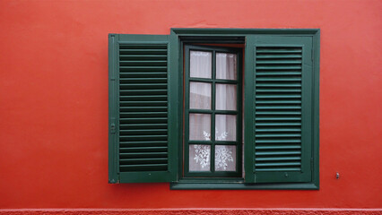 window with embroidered curtain on red wall, San Sebastian, Canary islands