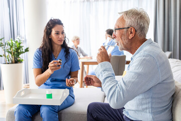 Obraz premium Female nurse talking to senior patient while being in a home visit.