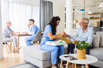Obraz premium Female nurse talking to senior patient while being in a home visit.