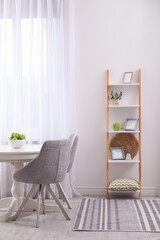Stylish living room interior with wooden ladder near white wall