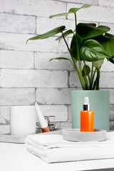 Face serum bottle on table at home bathroom. Minimal styling. Beauty blogging, skin care ad mock up with copy space