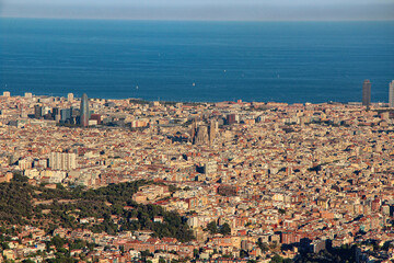 Obraz premium Top view of Barcelona Spain, yellow houses with red roofs, cathedrals, blue sky and blue sea with yachts. Soft focus