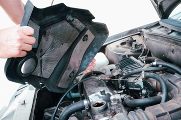 Car repair. Auto mechanic working on car engine in mechanics garage. Repair service. Close up of car mechanic repairer technician repairs auto engine
