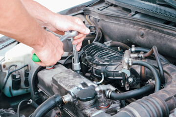 Car repair. Auto mechanic working on car engine in mechanics garage. Repair service. close-up shot