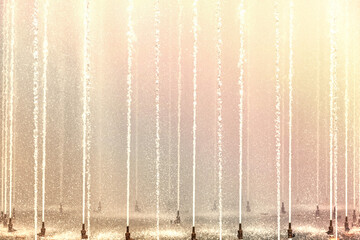 Background of multicolored jets and splashes of a fountain in the park