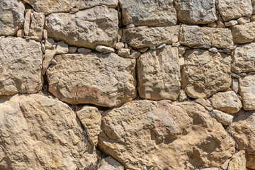 Real antique greek stonewall in sunny day background texture. Detail.