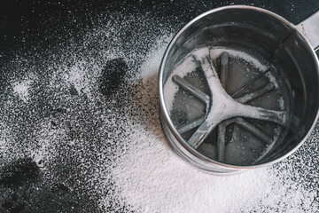 Mechanical bowl sieve for sifting flour from stainless steel with a handle. Mug seeder for flour.