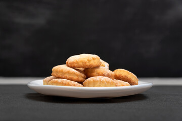 Delicious homemade shortcake on white plate, black background. Side view. Fresh shortbread.
