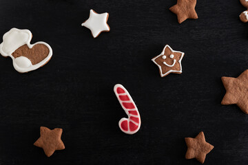 Gingerbread candy cane and stars cookies on black background. Traditional pastries
