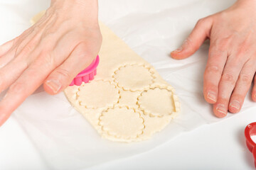 Female hands, cookie cutters and dough. Chef prepares cookies. Process of making homemade cookies.