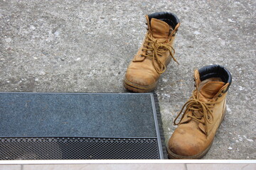 Abgestellte Schuhe vor der Fussmatte