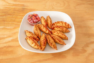 Large portion of Chinese dumplings stuffed with meat, gyozas, fried in oil and garnished with chopped vegetables